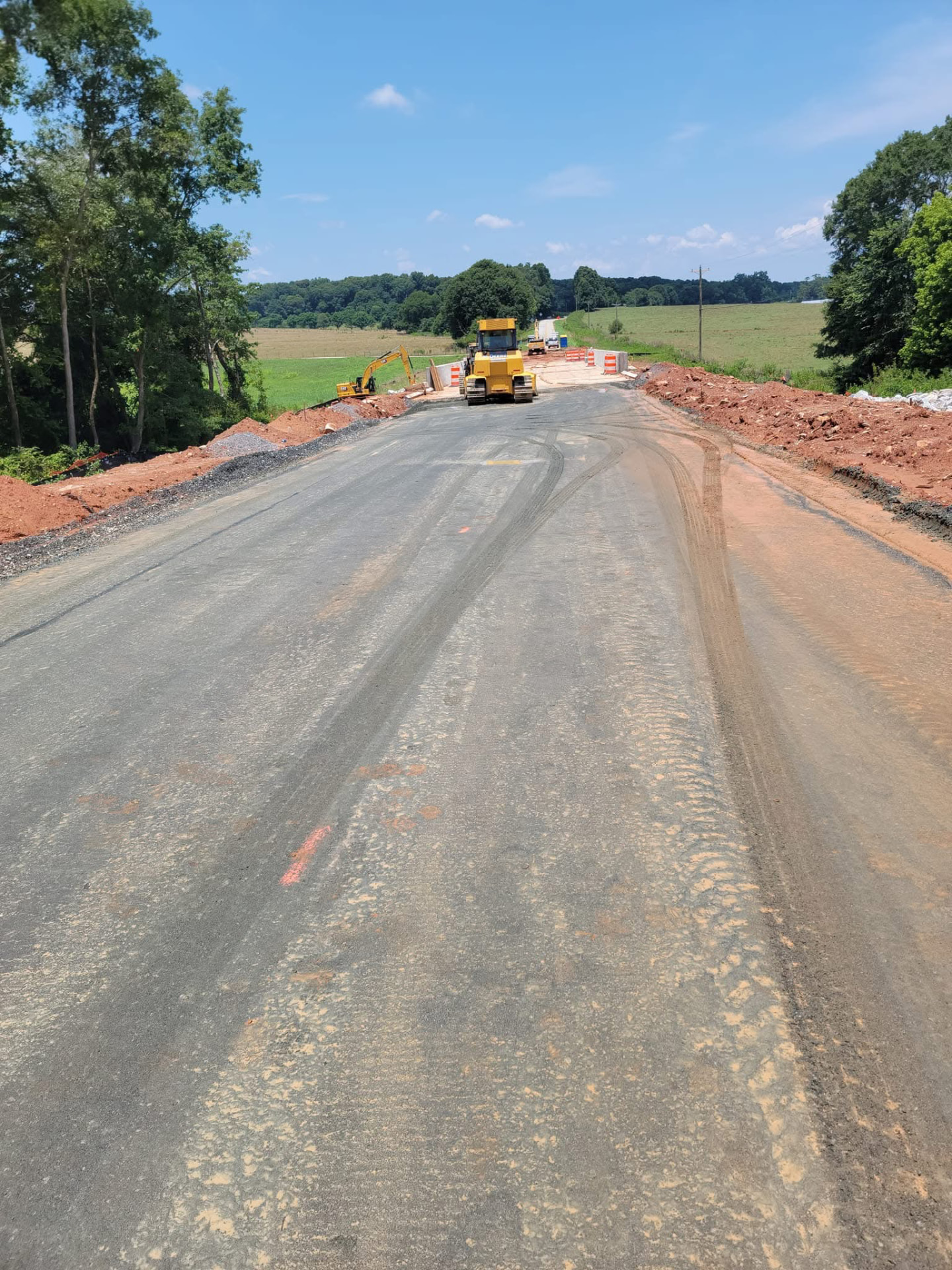 Heavy equipment completing grading work on a rural road